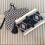 Ziptop embroidered or weaved clutches with a tassel or pompoms. Lined.  Practical beach or summer accessory with a touch of fun.  Embroidered diamond clutch with a black tassel 12" x 8"  Weaved diamond pattern with black/white pompoms 13" x 9"by Two b's accessories